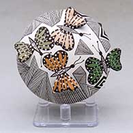 A polychrome seed pot decorated with butterfly wing appliques and a butterfly, fineline and geometric design
 by Alisha Sanchez of Acoma