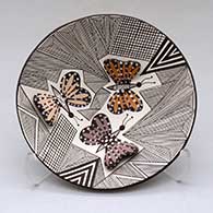A small polychrome plate decorated with butterfly wing appliques and a butterfly, fineline and geometric design
 by Alisha Sanchez of Acoma