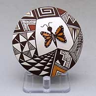 A polychrome seed pot decorated with butterfly wing and lady bug appliques and a butterfly, fineline and geometric design
 by Carolyn Concho of Acoma