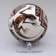 A polychrome seed pot decorated with lizard head and tail appliques and a lizard and geometric design
 by Carolyn Concho of Acoma