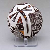 A polychrome seed pot decorated with dragonfly body and lady bug appliques and a dragonfly, fineline and geometric design
 by Carolyn Concho of Acoma