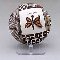 A polychrome seed pot decorated with butterfly wing and lady bug appliques and a butterfly, fineline, checkerboard and geometric design
 by Carolyn Concho of Acoma