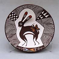 A polychrome plate decorated with rabbit ear and lady bug appliques and a Mimbres rabbit, butterfly, fineline and geometric design
 by Carolyn Concho of Acoma