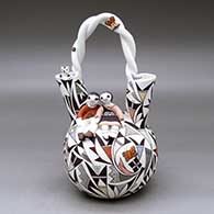 Click for a larger view A polychrome wedding vase with two children sitting near the top with cats, lady bugs, bird, lizard and butterfly appliques mixed in with a geometric design
by Judy Lewis of Acoma