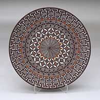 A polychrome plate decorated with a North Star fineline, yucca leaf snowflake and geometric design
 by Rebecca Lucario of Acoma