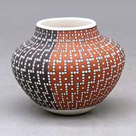 A small jar decorated with a four-panel geometric design built of tiny colored squares
 by Frederica Antonio of Acoma