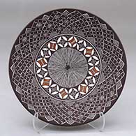 A polychrome plate decorated with a fineline, yucca leaf snowflake and geometric design
 by Amanda Lucario of Acoma