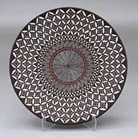 A polychrome plate decorated with a North Star fineline, yucca leaf snowflake and geometric design
 by Amanda Lucario of Acoma