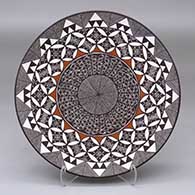 A polychrome plate decorated with a fineline, yucca leaf snowflake and geometric design
 by Amanda Lucario of Acoma