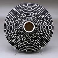 A black on white flat jar with a round neck and opening, decorated with a geometric design above and below
 by Paula Estevan of Acoma