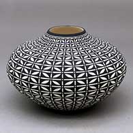 A black on white jar decorated with a butterfly and geometric design
 by Paula Estevan of Acoma