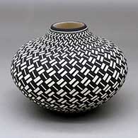A black on white jar decorated with a basket weave geometric design
 by Paula Estevan of Acoma