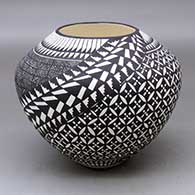 A black on white jar decorated with a fineline, pumpkin seed snowflake, kiva step and geometric design
 by Sandra Victorino of Acoma