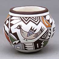 A small polychrome jar decorated with a four panel design featuring birds, a dragonfly and a butterfly surrounded by geometric elements
 by Judy Lewis of Acoma