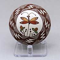 A polychrome seed pot decorated with a dragonfly, plant, lightning bolt, fineline and geometric design
 by Diane Lewis of Acoma