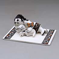 A tile with appliques of a girl and cat reclining with a butterfly, decorated with a geometric design
 by Marilyn Ray of Acoma