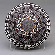 A polychrome seed pot decorated on top with a fineline and geometric design
 by Rebecca Lucario of Acoma