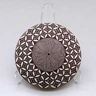 A black on white seed pot decorated on top with a fineline, yucca leaf snowflake and geometric design
 by Rebecca Lucario of Acoma