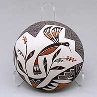 A polychrome seed pot decorated on top with a hummingbird, flower, fineline and geometric design
 by Rebecca Lucario of Acoma