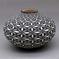 A black on white jar decorated with a pumpkin seed and geometric design
 by Paula Estevan of Acoma