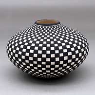 A black on white jar decorated with a checkerboard geometric design
 by Paula Estevan of Acoma