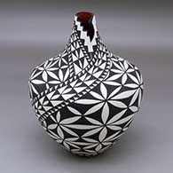 A black on white tear drop jar with a kiva step cut opening and decorated with a pumpkin seed snowflake and geometric design
 by Sandra Victorino of Acoma
