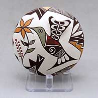 A polychrome seed pot decorated with hummingbird wing and lady bug appliques and a painted hummingbird, lady bug, flower, fineline and geometric design
 by Carolyn Concho of Acoma