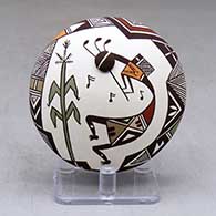 A polychrome seed pot decorated with kokopelli head and lady bug appliques and a painted kokopelli, lady bug, corn stalk, fineline and geometric design
 by Carolyn Concho of Acoma