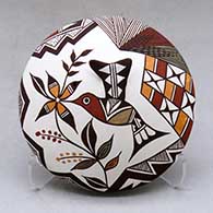 A polychrome seed pot decorated with a hummingbird wing applique and a painted hummingbird, flower, fineline and geometric design
 by Carolyn Concho of Acoma