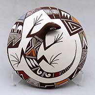 A polychrome seed pot decorated with lizard head and tail appliques and a painted fineline and geometric design
 by Carolyn Concho of Acoma