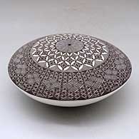 A black on white seed pot decorated above the shoulder with a North Star fineline and geometric design, click or tap to see a larger version