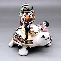 A polychrome turtle figure with three children, a pot, painted lady bug, lizard and butterfly appliques plus a parrot and geometric design
 by Marilyn Ray of Acoma