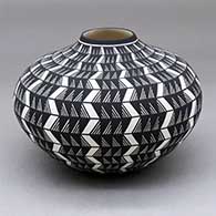 A black on white jar decorated with a lightning bolt, fineline and geometric design
 by Paula Estevan of Acoma