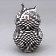 A polychrome owl figure decorated with a checkerboard tiny square and geometric design
 by Frederica Antonio of Acoma