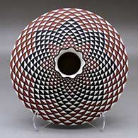A polychrome low shouldered jar with a pie crust rim and decorated with a spiral mesa geometric design
 by Paula Estevan of Acoma