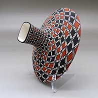 A polychrome low shouldered jar with a squarish neck and rim and decorated with a spiral checkerboard and geometric design, click or tap to see a larger version