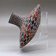 A polychrome low shouldered jar with a squarish neck and rim and decorated with a spiral checkerboard and geometric design, click or tap to see a larger version