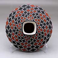 A polychrome low shouldered jar with a squarish neck and rim and decorated with a spiral checkerboard and geometric design
 by Paula Estevan of Acoma