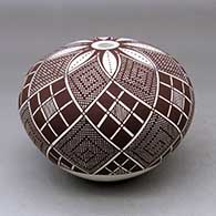 A black on white seed pot decorated with an eight panel stylized checkerboard, tiny squares and geometric design
 by Robert Patricio of Acoma