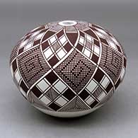 A black on white seed pot decorated with an eight panel stylized checkerboard, tiny squares and geometric design
 by Robert Patricio of Acoma