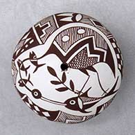 A miniature black on white seed pot decorated above the shoulder with a cloudeater, fish and geometric design
 by Diane Lewis of Acoma