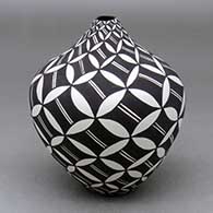 A black on white tear drop jar decorated with a spiraling pumpkin seed snowflake and geometric design
 by Sandra Victorino of Acoma