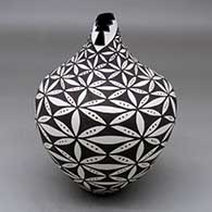 A polychrome tear drop jar with a kiva step cut opening and decorated with a pumpkin seed snowflake and geometric design
 by Sandra Victorino of Acoma