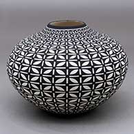 A black on white jar decorated with a stylized butterfly and geometric design
 by Paula Estevan of Acoma