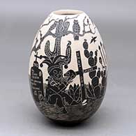 A black on white jar decorated with a sgraffito Day of the Dead design
 by Diana Loya of Mata Ortiz and Casas Grandes
