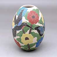 A polychrome jar decorated with a sgraffito and painted bird, butterfly, branch, leaf and flower design
 by Blanca Arras of Mata Ortiz and Casas Grandes