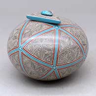 A polychrome jar with a triangular lid with an inlaid stone and decorated with a spiral fineline and geometric design
 by Oralia Lopez of Mata Ortiz and Casas Grandes