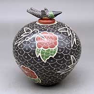 A polychrome jar decorated with a lightly carved, sgraffito and painted hummingbird, flower and mesh design, plus a hummingbird on the lid
 by Vidal Corona of Mata Ortiz and Casas Grandes