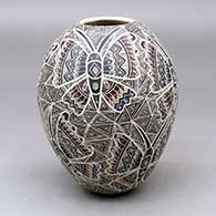 A polychrome jar decorated with a lightly-carved, sgraffito and painted butterfly and geometric design
 by Ailadi Mijarez of Mata Ortiz and Casas Grandes