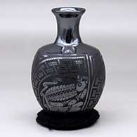 A black on glossy black vase with a flared neck and decorated with a three panel bird element and geometric design around the body
 by Eligio Ortiz of Mata Ortiz and Casas Grandes